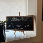 A small tabletop chalkboard with handwritten notes displayed on a wooden stand.