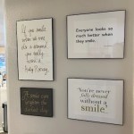 Three framed minimalist art pieces or quotes hanging on a neutral-colored wall.